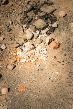 broken asphalt with brick rubble and construction debris close up