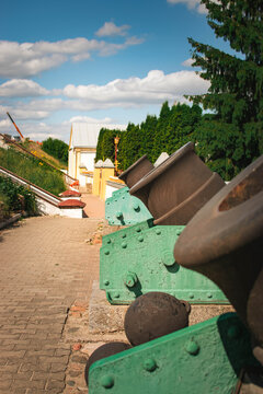 historic cannons displayed outdoors near museum buildings on sunny day