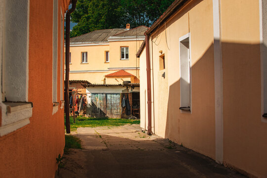 old residential courtyard with historic buildings and sunny passageway