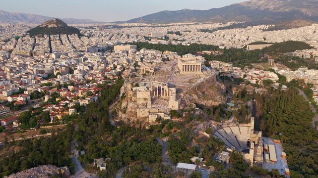 Majestic aerial view of the acropolis of athens with the iconic parthenon and the odeon of herodes atticus, revealing the historic city landscape and mount lycabettus in the background
