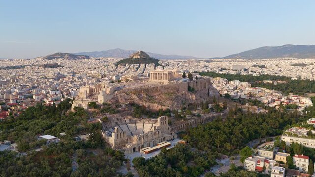 Amazing aerial panorama of athens showing the ancient acropolis with the parthenon and odeon of herodes atticus, with mount lycabettus and the sprawling city in the background at sunset