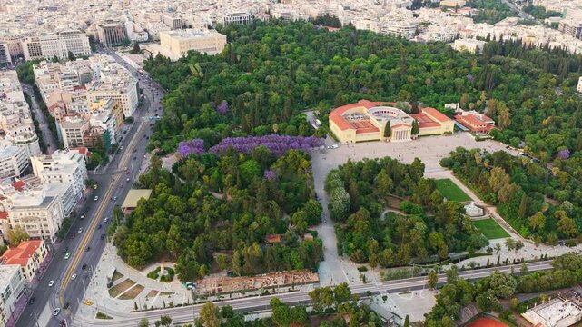 Aerial view of athens, greece, showcasing the lush national garden, the historic zappeion hall, the hellenic parliament building, and the bustling city streets surrounding these landmarks