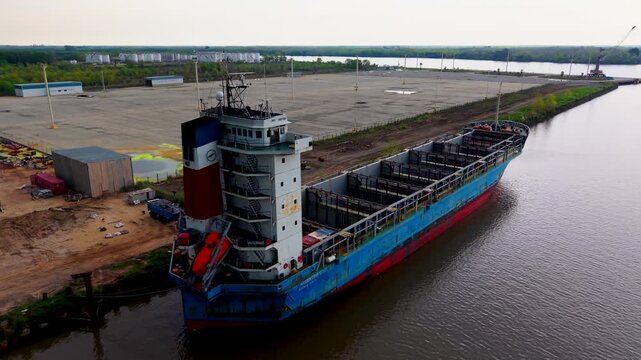 Barco de carga o buque de transporte de mercanc&iacute;as amarrado en el puerto, log&iacute;stica portuaria, comercio exterior, industria naviera, importaci&oacute;n, exportaci&oacute;n y transporte mar&iacute;timo