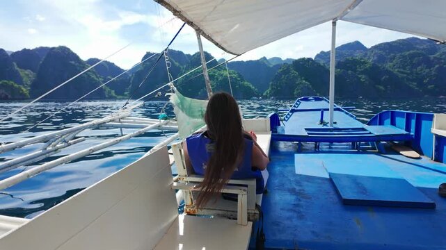 Tourist relaxes alone as private boat slowly glides across Coron island lagoons