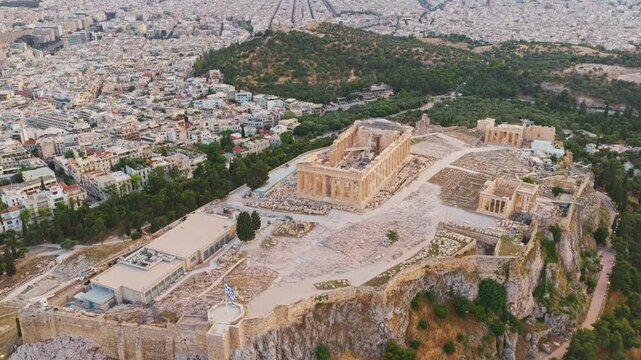 Majestic aerial footage flying over the ancient acropolis of athens, revealing the iconic parthenon, erechtheion, and surrounding cityscape of greece's historic capital city