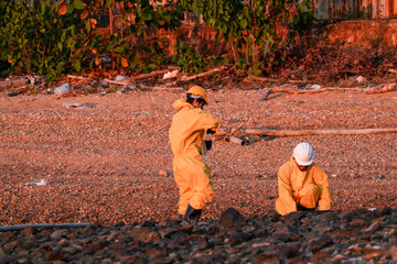 Fototapeta premium Environmental scientists in protective gear conducting water quality sampling and field analysis at a coastal site to assess contamination levels and ecological impact.