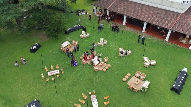 Evento social en una estancia al atardecer con gente celebrando, casamiento, festejo, festividad, reuni&oacute;n al aire libre, ambiente campestre y celebraci&oacute;n elegante