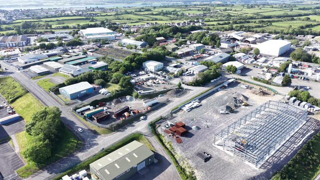 Aerial drone 4K footage showing caravans arranged beside countryside ridge greenery with warm natural tones across the terrain Wales