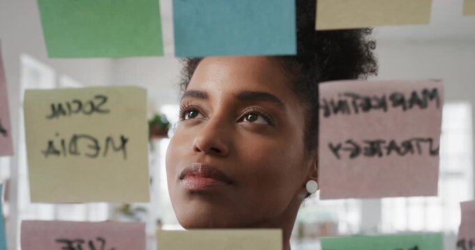 Business, woman and schedule with sticky notes in office for task priority, workflow or planning. Female person, planner or brainstorming with ideas, reminder or agenda for project or work delegation