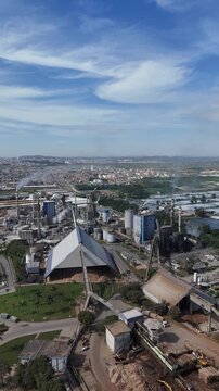 Filmagem a&eacute;rea vertical em 4K apresenta parque industrial de papel e celulose com estruturas operacionais e ampla &aacute;rea produtiva integrada.