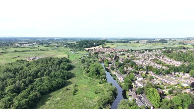 Aerial drone 4K footage showing a town district bordered by open countryside fields with warm natural tones Burton on Trent