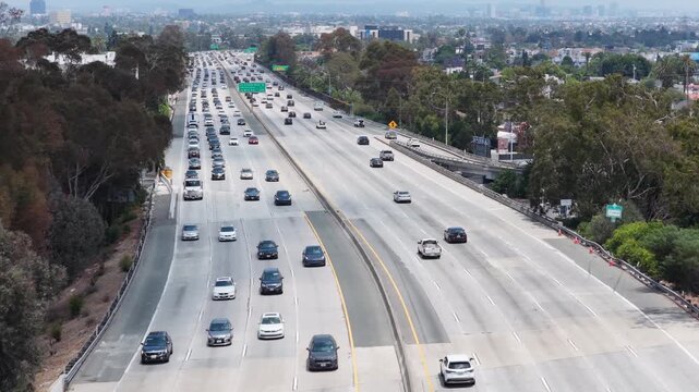 Los Angeles freeway displaying heavy traffic with multiple lanes of cars commuting through urban landscape, everyday city life and transportation infrastructure