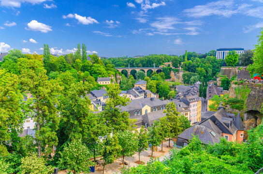Luxembourg City historical centre aerial panoramic view, old colorful buildings and green trees, Luxembourg cityscape skyline horizon with blue sky, panorama of Luxembourg old town Grund district