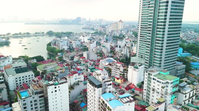 Hanoi cityscape aerial panorama showing modern skyscrapers and dense residential blocks clustered around truc bach and west lake, highlighting urban growth, waterways and rooftop textures