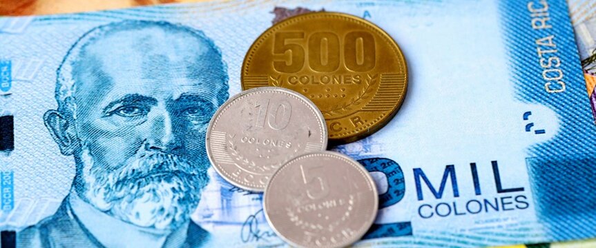 Costa Rican colon money bills and coins on table. Costa Rica cash of CRC currency close up