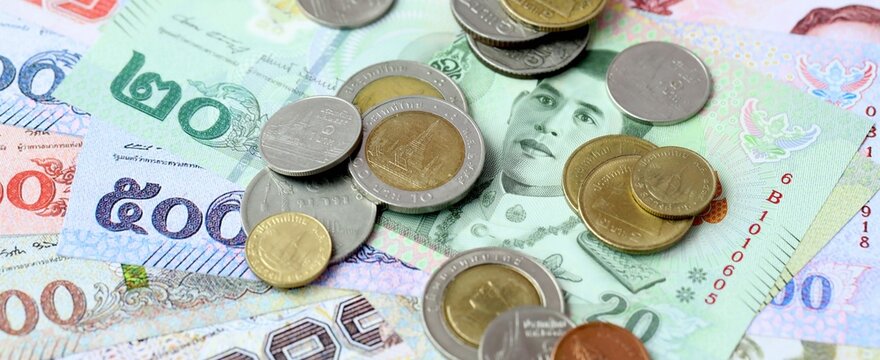Thai baht money bills and coins on table. Thailand cash of THB currency close up