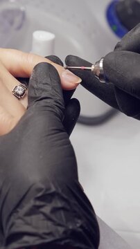Manicure process. Correction of female nails with drilling machine. Vertical footage
