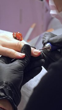 Manicure process. Correction of female nails with drilling machine. Vertical footage
