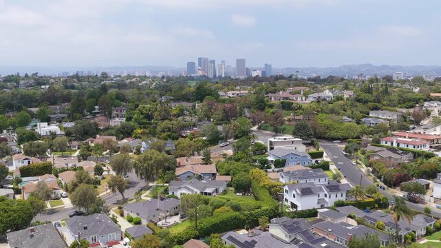 Unique tripod elevated perspective above wealthy Los Angeles neighborhood with iconic Century City skyline, residential properties and green landscape