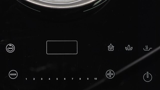 Adjust function on Induction stove and set power of heating, closeup
