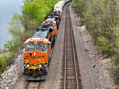 Savanna, Illinois - USA - April 24, 2026;Aerial view of a BNSF railroad locomotive pulling a freight train of cars along the backwaters of the Mississippi river