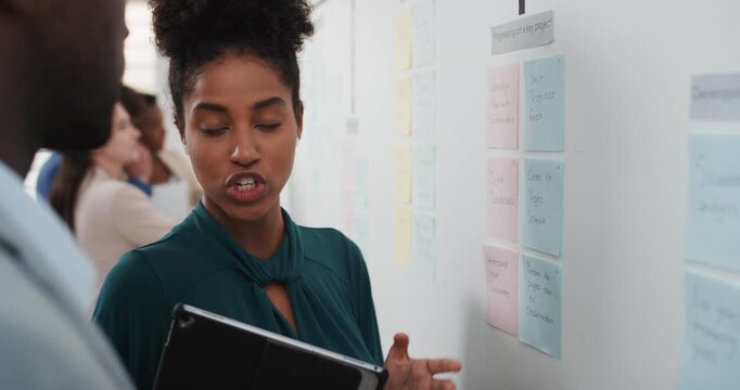 Woman, talking and notes on whiteboard in meeting for training, planning and agenda for audit. Office, team or discussion with storyboard for coaching, brainstorming and ideas for investment proposal