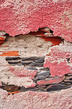 d&eacute;tail color&eacute; de texture sur un mur d&eacute;cr&eacute;pi de la fa&ccedil;ade d'une vielle maison en b&eacute;ton et briques rose