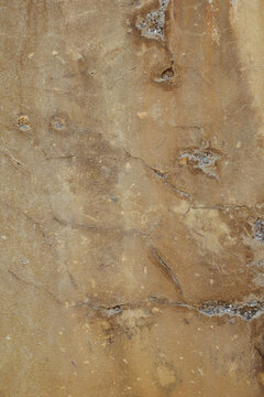 d&eacute;tail de texture sur un mur d&eacute;cr&eacute;pi ocre et marron de la fa&ccedil;ade d'une vieille maison en b&eacute;ton 