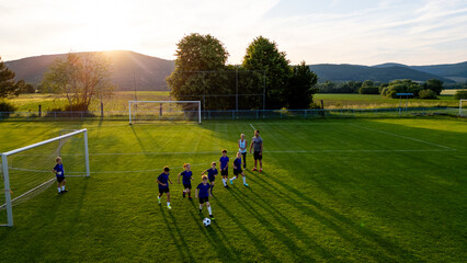 Naklejka premium Children playing soccer game during youth football practice.