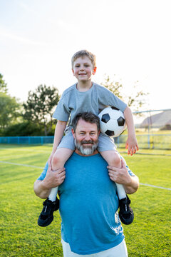 Dad and son sharing passion for football and active lifestyle.