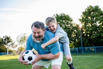 Dad and son sharing passion for football and active lifestyle.