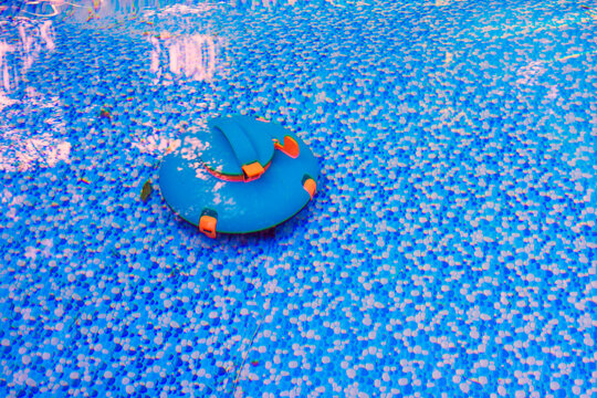 Floating robotic vacuum is works on blue surface in swimming pool