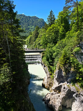 germany, dramatic canyon perspective toward famous tourist bridge above lechfall waterfall and pristine forest landscape