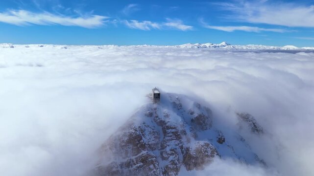 Aerial drone footage flying above a sea of thick clouds surrounding Mount Olympos summit in Antalya Turkey