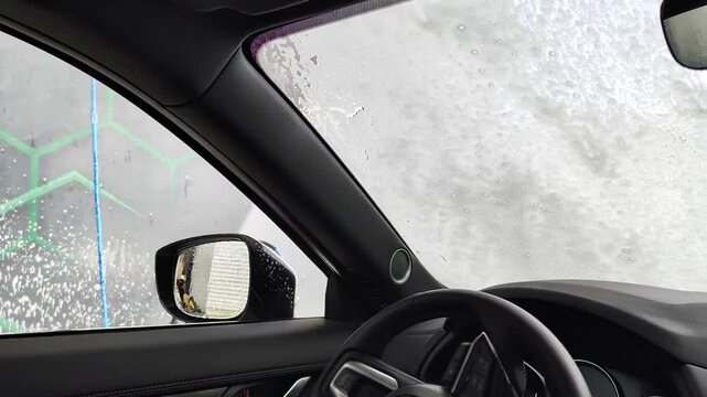 Inside Car View Of Man Washing Windshield And Side Mirror At Self Service Station