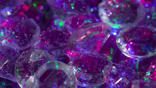 Diamond Facets Sparkle in Laser Light. Small crystals with a classic cut on a mirror surface slowly move in front of the camera, shimmering in the laser beams