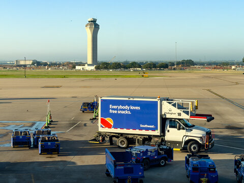 Denver International airport exterior view with Southwest airlines trucks and Air Traffic Control Tower