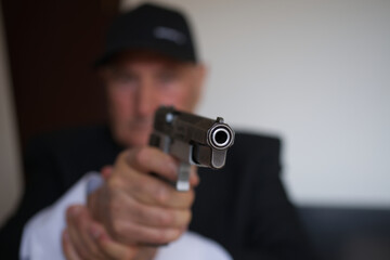 Obraz premium Handgun in the hands of uniformed man in soft bokeh background