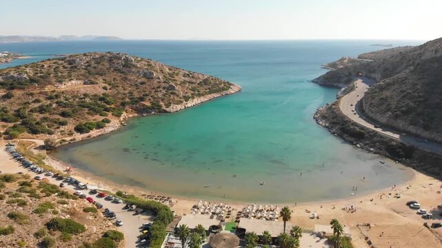 Aerial view of beach Paralia Lomvarda beach near Athens, Greece and seaside. Drone view from above. Sea and coast with sandy beach. Summer destination on the Mediterranean Sea, Europe
