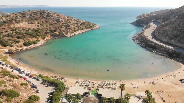 Aerial view of beach Paralia Lomvarda beach near Athens, Greece and seaside. Drone view from above. Sea and coast with sandy beach. Summer destination on the Mediterranean Sea, Europe
