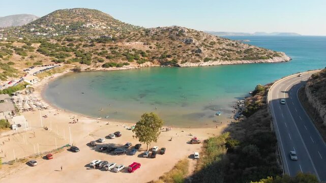 Aerial view of beach Paralia Lomvarda beach near Athens, Greece and seaside. Drone view from above. Sea and coast with sandy beach. Summer destination on the Mediterranean Sea, Europe
