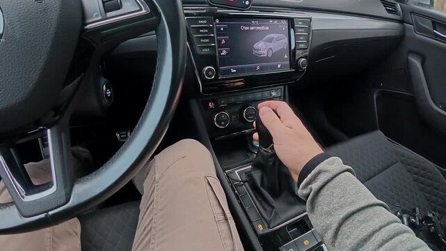 Driving with hands on the gear shift and screen showing navigation while making turns in a small town during the day