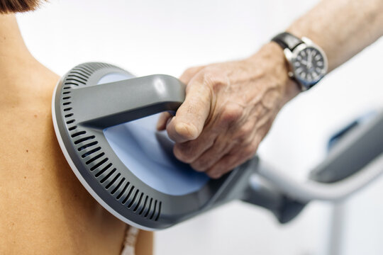 Female patient undergoing electromagnetic back therapy in advanced medical center. Concept rehabilitation, wellness and non-invasive treatment.
