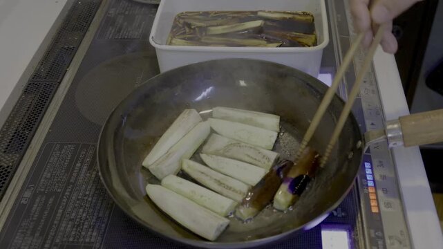 茄子を煮浸し用に焼き、茄子を引っくり返すシーン