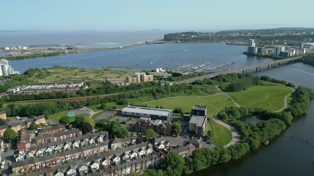 4K Aerial Drone Shot Flying Toward Cardiff Bay Barrage, Hamadryad Park,Wetlands Reserve, Cardiff Yacht Club, and Cardiff, Wales, United Kingdom, with Car Passing Over Cardiff Bay Link Bridge