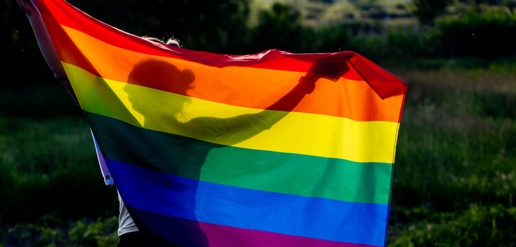 person holding rainbow flag for prode month