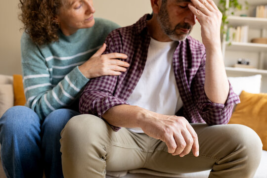 Woman comforting distressed man experiencing mental stress and sadness