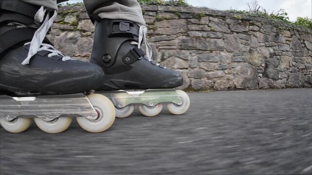 Powerful closeup action of man skating fast on inline skates showing dynamic motion, speed, technique, outdoor fitness and urban energy