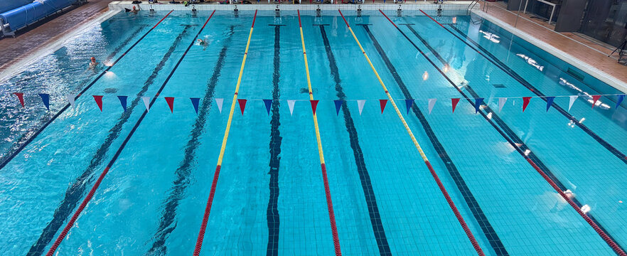 swimming in indoor pool, lane lines, flags, concept of tourism, sports, fitness, copyspace