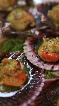 Delicious grilled scallops served in shells with a fresh green sauce, lime, and seasoning. A perfect gourmet appetizer from a fine dining menu